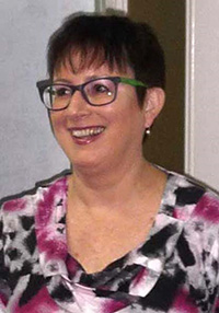 photograph of a smiling woman wearing glasses.