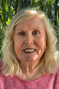 close up photograph of a woman in front of a wall.